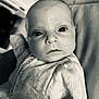 baby, infant, face, eyes, onesie, patterned_clothing, closeup, portrait, skin, head, expression, curious, black_and_white, texture, fabric, newborn, child, person, indoor, soft_light