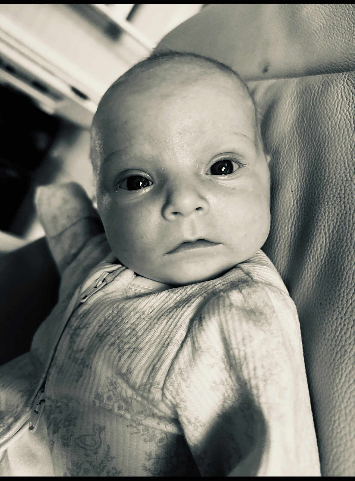 Florrie is registered to the contest to win money with this photo: baby, infant, face, eyes, onesie, patterned_clothing, closeup, portrait, skin, head, expression, curious, black_and_white, texture, fabric, newborn, child, person, indoor, soft_light