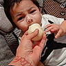 baby, child, hand, fruit, peach, cushion, seat, tattoo, clothing, infant, person, indoor, portrait, feeding, curious, skin, face, expression, young, comfort