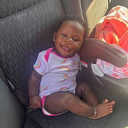 Jaloni is registered to the contest to win money with this photo: baby, child, car_seat, onesie, rainbow_pattern, smiling, anklet, blanket, sunlight, shadow, seatbelt, curly_hair, infant, indoors, cute, happy, comfortable, clothing, person, portrait