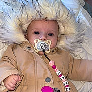Layna participe au concours pour gagner de l'argent avec cette photo : baby, child, pacifier, beads, clothing, jacket, hood, fur_hood, blanket, indoor, cute, infant, portrait, warm_clothing, face, hand, button, pink, white, soft