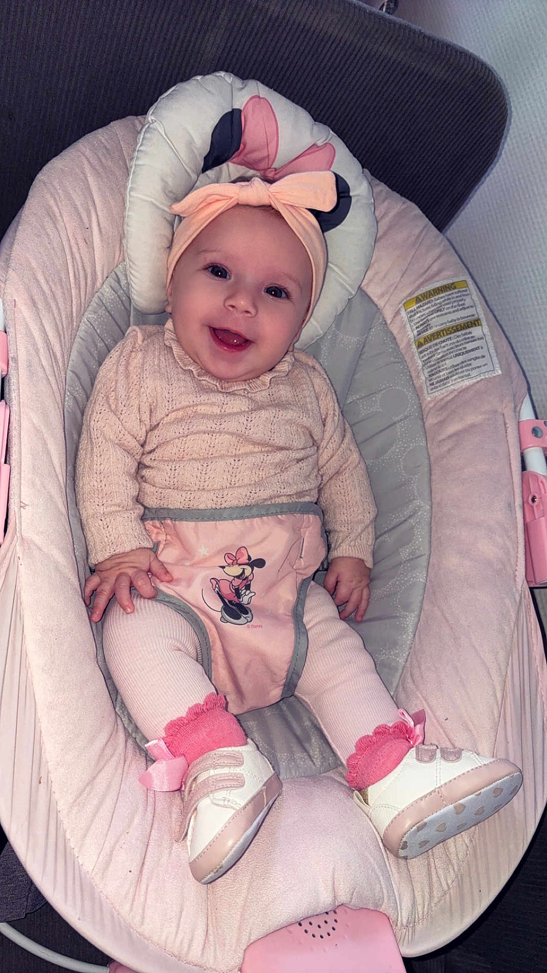 Layna participe au concours pour gagner de l'argent avec cette photo : baby, infant, smiling, headband, bow, pink, knit_sweater, baby_rocker, cushion, shoes, socks, minnie_mouse, clothing, cute, happy, child, portrait, indoor, person, seat