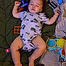 Madden is registered to the contest to win money with this photo: baby, sleeping, infant, toy, blanket, onesie, indoor, child, cute, peaceful, colorful, drum, blocks, foot, hand, face, curly_hair, lying_down, soft_lighting, relaxation