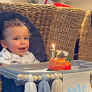 Madden joined the competition — help win amazing prizes! toddler, high_chair, birthday_cake, candle, celebration, child, smiling, indoor, woven_chair, table, decorations, adult, clapping, happy, curly_hair, food, party, family, home, festive