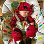 baby, baby_seat, black_socks, carpet, child, comfort, cute, face, furniture, hand, headwear, indoors, infant, patterned_fabric, peaceful, plush, red_clothing, rest, sleeping, toddler