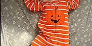 Nio joined the competition — help win amazing prizes! baby, sleeping, onesie, orange, white_stripes, pumpkin, star_pattern, blanket, infant, cute, cozy, peaceful, child, footed_pajamas, face, hands_up, lying_down, indoors, soft_fabric, resting