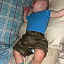 Nio is registered to the contest to win money with this photo: arm, baby, bed, blanket, blue_shirt, camo_shorts, child, comfort, cozy, head, indoor, infant, leg, nap, person, pillow, resting, sleeping, soft, turquoise_socks