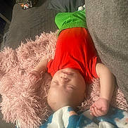 Nio joined the competition — help win amazing prizes! baby, sleeping, pillow, red_shirt, green_pants, blanket, couch, indoor, child, peaceful, resting, soft_texture, cozy, infant, relaxed, home, furniture, person, toddler, nap