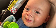 Nio joined the competition — help win amazing prizes! baby, blue_bib, car_seat, child, closeup, clothing, cute, eyes, face, green_toy, happy, head, indoor, infant, mouth, portrait, safety_warning, seatbelt, skin, smiling