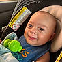 baby, blue_bib, car_seat, child, closeup, clothing, cute, eyes, face, green_toy, happy, head, indoor, infant, mouth, portrait, safety_warning, seatbelt, skin, smiling