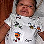 Sevyen is registered to the contest to win money with this photo: baby, infant, onesie, clothing, blanket, lying_down, face, expression, cartoon, sports, football, basketball, soft, cute, child, person, indoors, smile, head, hair
