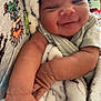 baby, smiling, face, arm, blanket, cozy, infant, child, cute, sleepwear, soft, happy, closeup, person, skin, pattern, cartoon, fabric, colorful, indoor