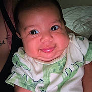 Tadeo is registered to the contest to win money with this photo: arm, baby, child, chubby_cheeks, clothing, cute, dinosaur_print, drool, eyes, face, happy, holding, indoor, infant, onesie, person, portrait, skin, smile, young