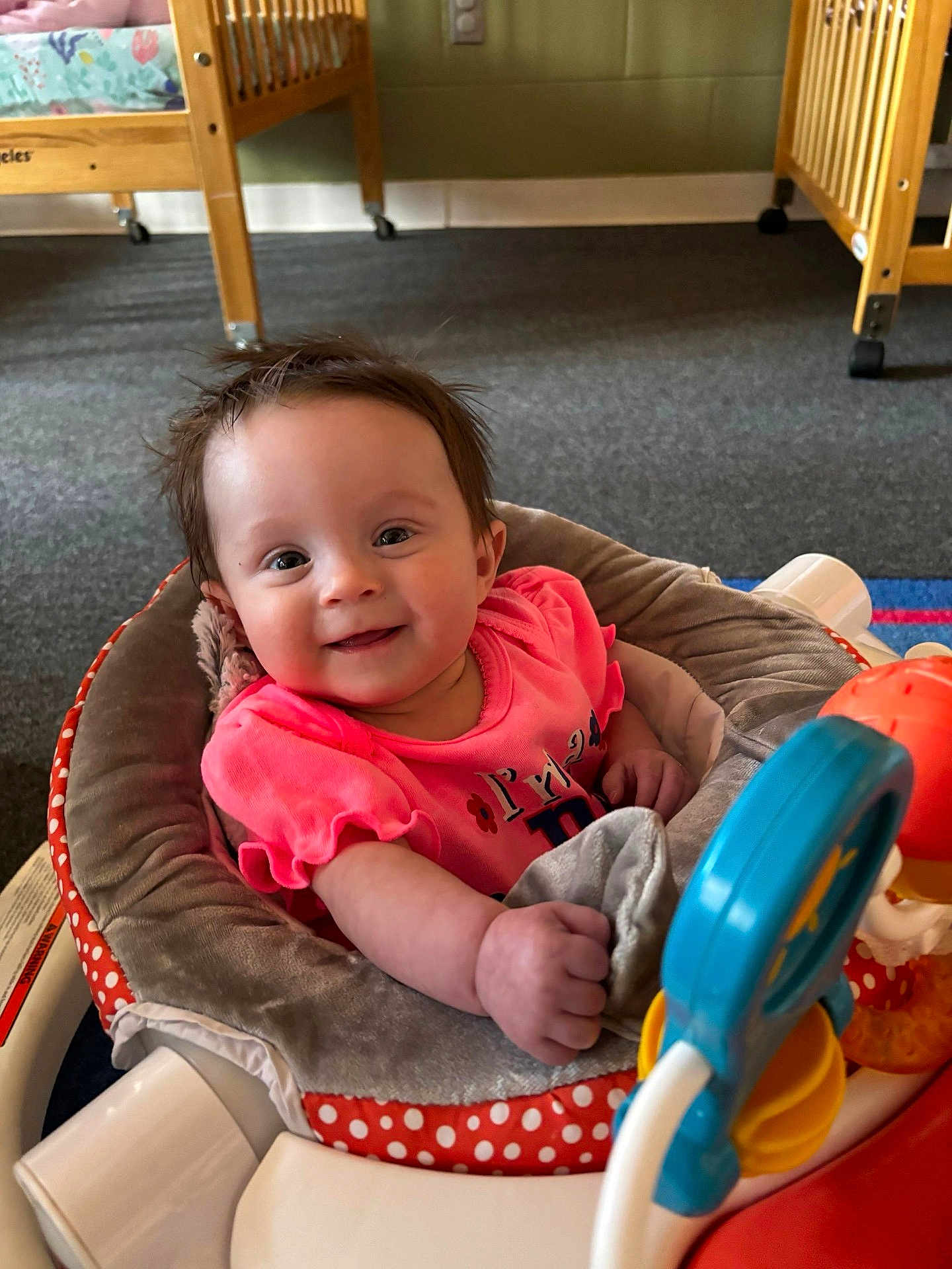 Brooke joined the competition — help win amazing prizes! baby, infant, smile, pink_shirt, baby_walker, toy, indoor, carpet, wooden_crib, child, happy, face, person, cute, play, toddler, room, seat, clothing, furniture