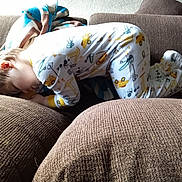 Tobias is registered to the contest to win money with this photo: baby, bed_sheet, bedding, bedtime, child, comfort, couch, flooring, foot, grass, human_leg, knee, linens, nap, pattern, room, sitting, thigh, toddler, wood