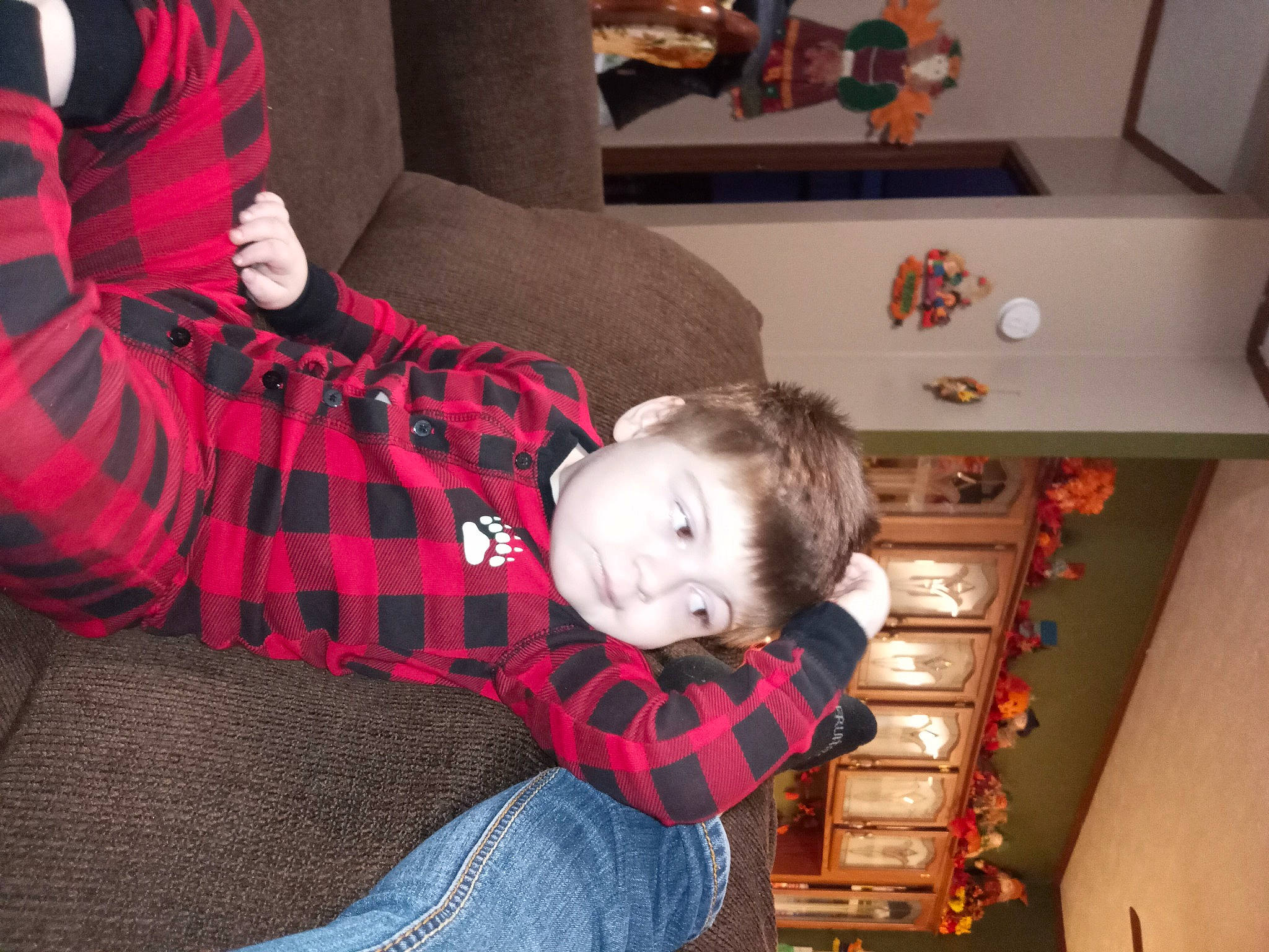 Tobias is registered to the contest to win money with this photo: baby, baby_toddler_clothing, child, comfort, couch, fun, holiday, human_body, lap, leg, person, picture_frame, plaid, red, shelf, sitting, sock, tartan, toddler, tree