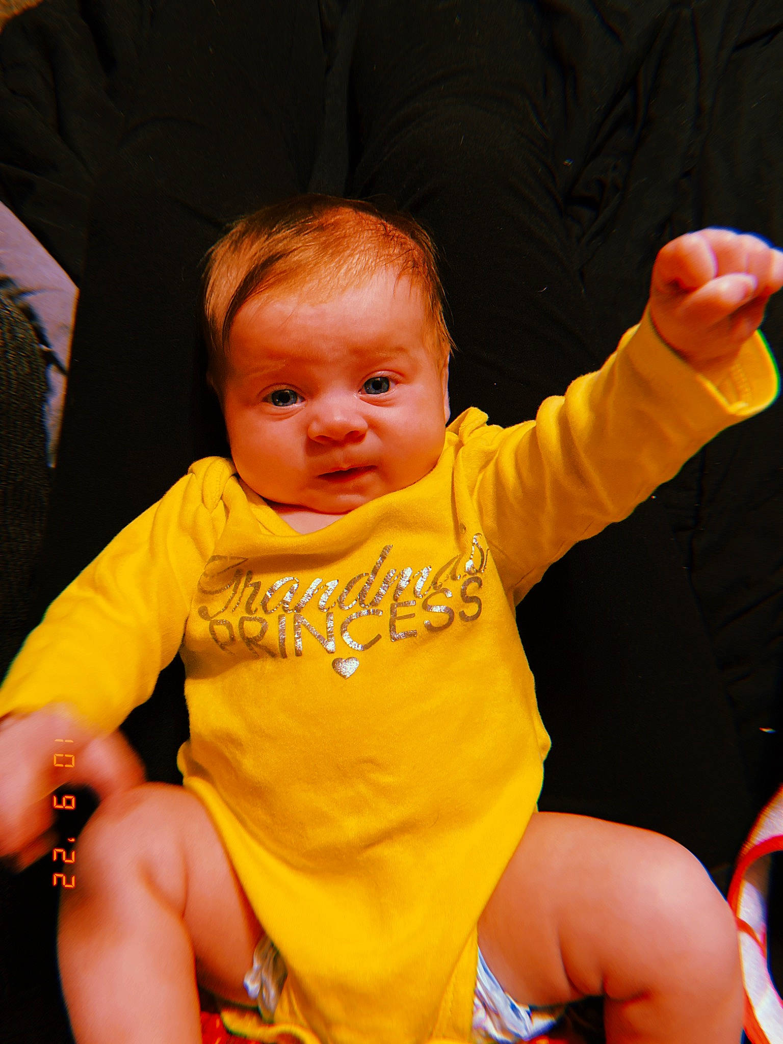 Ariya is registered to the contest to win money with this photo: baby, baby_toddler_clothing, chair, cheek, child, event, facial_expression, finger, fun, gesture, hairstyle, hand, happy, head, human_body, lap, person, product, skin, thumb