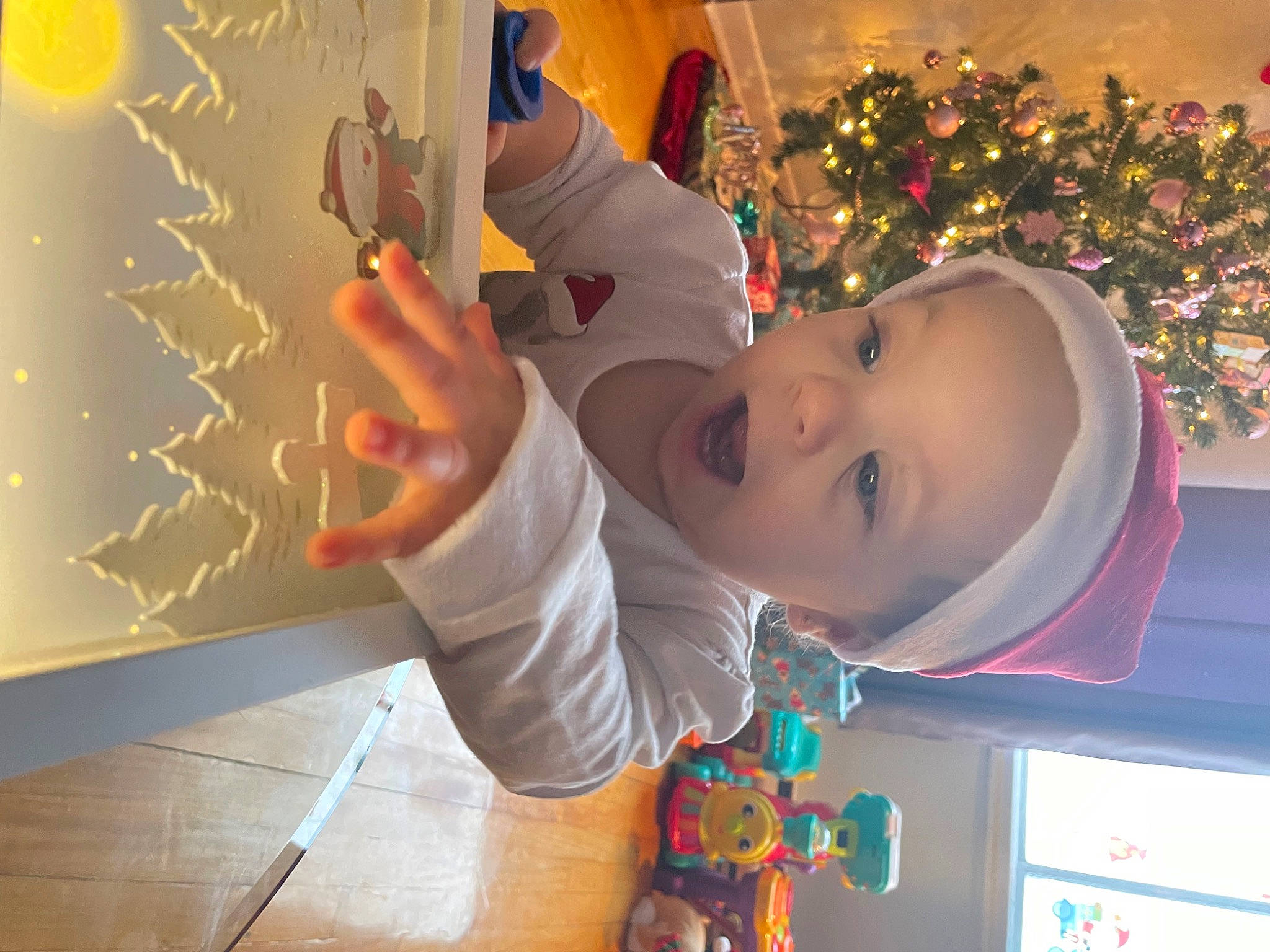 Sarah Jeanne participe au concours pour gagner de l'argent avec cette photo : arm, artist, child, christmas, christmas_ornament, christmas_tree, event, finger, fun, gesture, happy, headwear, holiday, leisure, person, room, smile, snapshot, standing, toddler