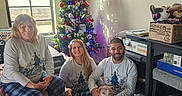 Zoey joined the competition — help win amazing prizes! casual_clothing, christmas_tree, cozy, decorations, dog, family, festive, floor, holiday, indoor, pajamas, people, pets, plush_toy, room, seated, shadow, smiling, sunlight, window