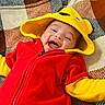 Cristian joined the competition — help win amazing prizes! baby, child, smiling, hood, red_clothing, yellow_clothing, blanket, happy, cute, infant, face, apparel, warm_clothing, patterned_blanket, lying_down, joyful, small_person, indoor, portrait, playful