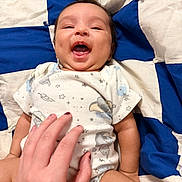 Cristian joined the competition — help win amazing prizes! baby, smiling, hand, blanket, blue, white, onesie, infant, happy, toddler, skin, face, lying_down, cute, playful, human, child, tickling, indoors, fabric