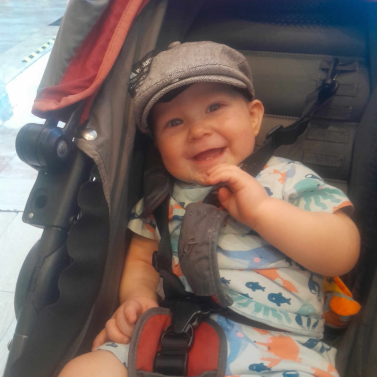 Reuben joined the competition — help win amazing prizes! baby, cap, child, clothing, colorful, comfort, cute, expression, face, hand, happy, indoor, infant, joy, pattern, playful, seatbelt, sitting, smile, stroller