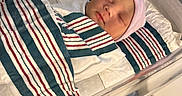 Draesyn is registered to the contest to win money with this photo: newborn, baby, hospital, bassinet, blanket, striped, pacifier, sleeping, infant, hat, bed, medical, nursery, person, cute, wrapped, resting, healthcare, closeup, indoors