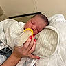 newborn, baby, bottle, feeding, blanket, sleeping, person, hand, nail_polish, red_nails, skin, indoor, comfort, rest, infant, clothing, bed, soft, care, peaceful