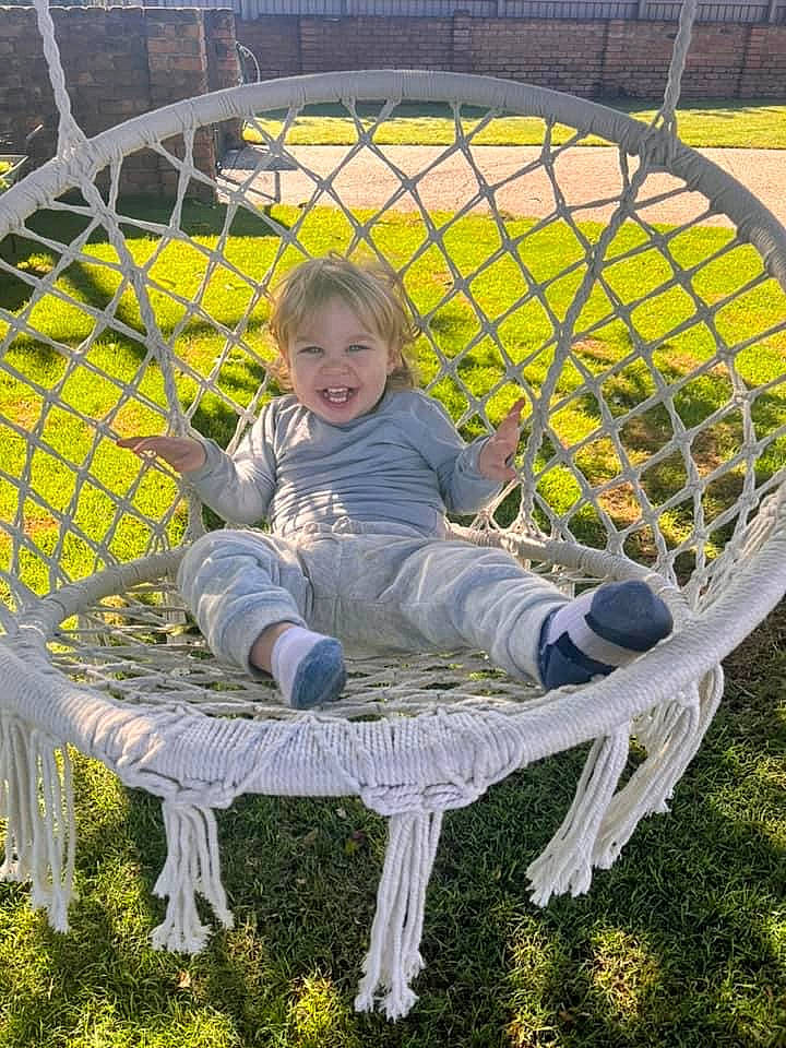Calais is registered to the contest to win money with this photo: baby_products, ball, chair, child, fun, grass, joy, lawn, leisure, mesh, net, pattern, people_in_nature, person, plant, recreation, sitting, smile, sports_equipment, toddler