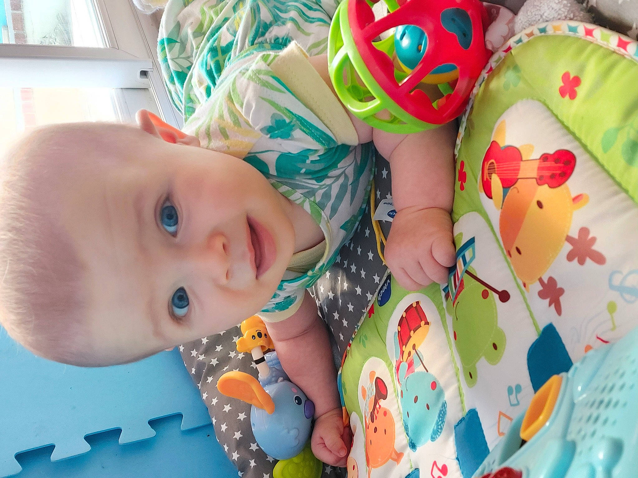 Lana participe au concours pour gagner de l'argent avec cette photo : baby, baby_toddler_clothing, bookcase, cheek, child, eye, face, fun, green, happy, head, human_body, mouth, nose, pattern, person, shelf, skin, smile, toddler