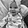 Evelyn joined the competition — help win amazing prizes! baby, child, smile, bow, headband, floral_pattern, clothing, blanket, texture, cute, portrait, sitting, happy, infant, face, apparel, cozy, monochrome, young, fashion