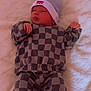 Mathias is registered to the contest to win money with this photo: baby, infant, hat, clothing, checkered_pattern, blanket, lying_down, cute, soft_texture, comfortable, child, small_hands, face, headwear, apparel, indoor, portrait, resting, young_child, fashion