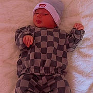 Mathias joined the competition — help win amazing prizes! baby, infant, checkered_clothing, beanie, hat, lying_down, blanket, soft_texture, cute, sleepy, small_hands, infant_clothing, cozy, indoor, newborn, child, person, portrait, resting, casual_wear