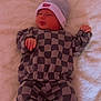 baby, infant, checkered_clothing, beanie, hat, lying_down, blanket, soft_texture, cute, sleepy, small_hands, infant_clothing, cozy, indoor, newborn, child, person, portrait, resting, casual_wear