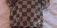 Mathias is registered to the contest to win money with this photo: baby, infant, checkered_clothing, hat, beanie, lying_down, blanket, soft_texture, cute, tongue_out, cozy, warm_clothes, newborn, child, socks, small_hands, relaxed, indoors, portrait, sleepwear