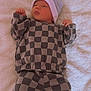 Mathias is registered to the contest to win money with this photo: baby, infant, checkered_clothing, hat, levis, socks, blanket, soft_texture, sleepwear, newborn, cute, lying_down, indoors, portrait, child, warm_clothing, resting, small_hands, cozy, casual
