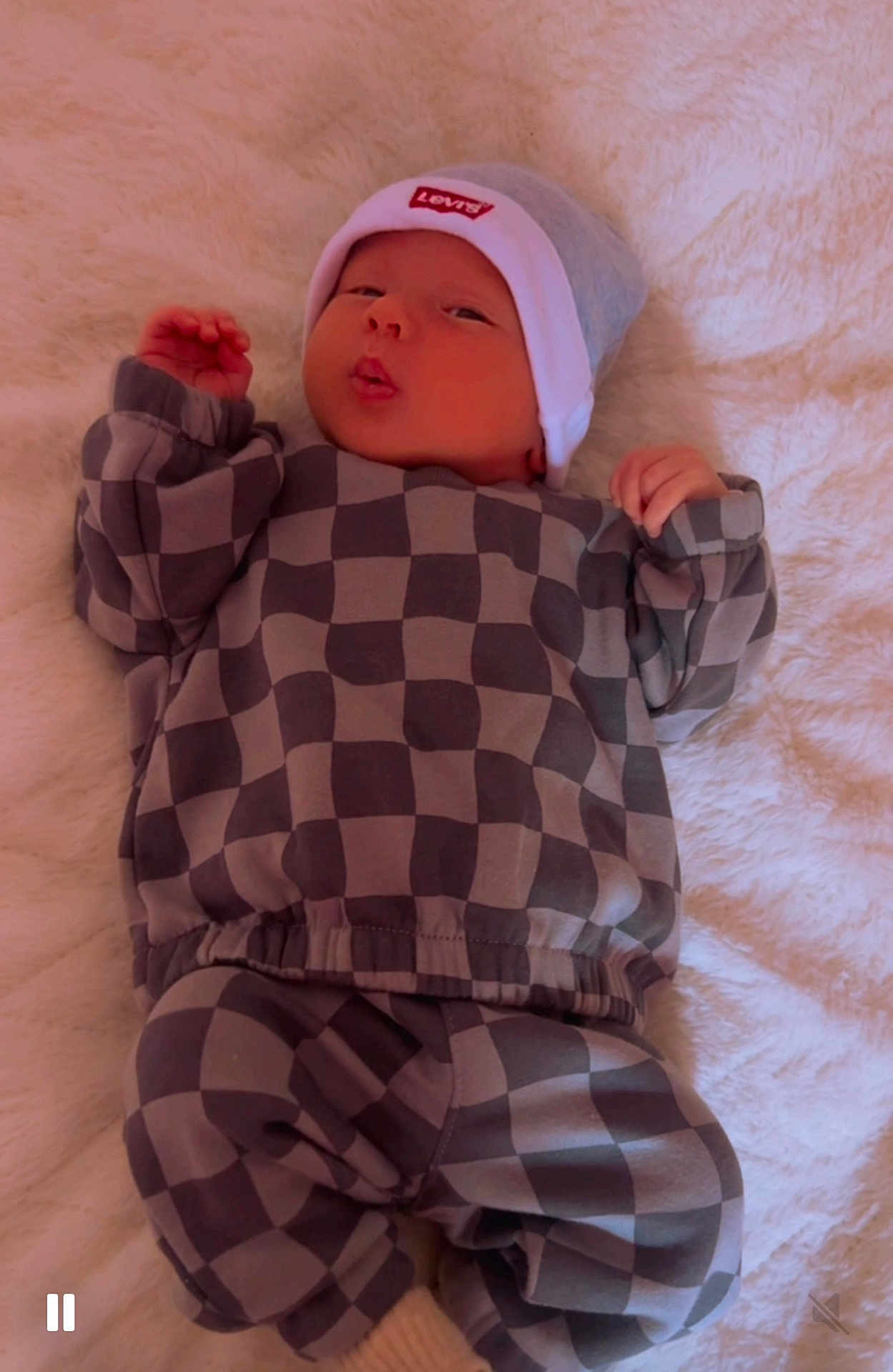 Mathias is registered to the contest to win money with this photo: baby, infant, checkered_clothing, hat, levis, blanket, cute, puckered_lips, lying_down, cozy, soft_texture, child, newborn, apparel, fashion, portrait, indoors, resting, adorable, warm