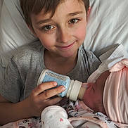 Nathan participe au concours pour gagner de l'argent avec cette photo : baby, bed, bottle, care, child, cute, family, feeding, hat, indoor, infant, love, newborn, onesie, pillow, portrait, sibling, sleepwear, smile, young