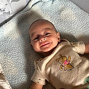 Mateo joined the competition — help win amazing prizes! baby, smiling, child, blanket, plush_toy, giraffe_toy, tshirt, winnie_the_pooh, infant, cute, lying_down, soft_texture, happy, indoors, face, head, arm, person, young_child, cozy