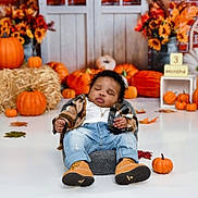 Mahdi is registered to the contest to win money with this photo: baby, sleeping, pumpkin, fall_decor, autumn, jeans, boots, plaid_jacket, indoor, hay_bale, flowers, orange, white_floor, child, cute, seasonal, holiday, cozy, background, portrait
