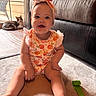 baby, carpet, cat, child, clothing, couch, cute, floor, furniture, glass_door, headband, home, indoor, infant, pet, playful, sitting, smiling, toy, window