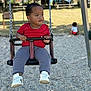 child, swing, playground, outdoor, park, trees, bench, grass, daylight, person, red_shirt, gray_pants, white_shoes, baby, play, fun, chain, seat, background, young