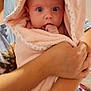 baby, child, infant, towel, hooded_towel, pink, person, arms, nursery, playmat, toy, wall_decal, indoor, holding, cute, wide_eyes, blanket, soft, comfort, portrait
