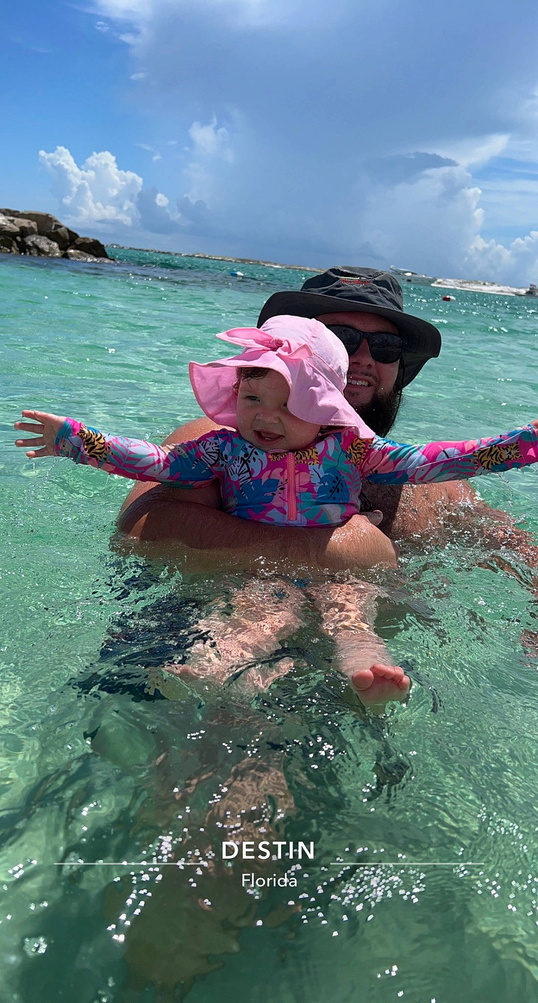 Maci is registered to the contest to win money with this photo: azure, boats_and_boating_equipment_and_supplies, cap, cloud, fun, goggles, hat, headwear, lake, leisure, lifejacket, ocean, person, personal_protective_equipment, recreation, sky, sports, sun_hat, toddler, travel