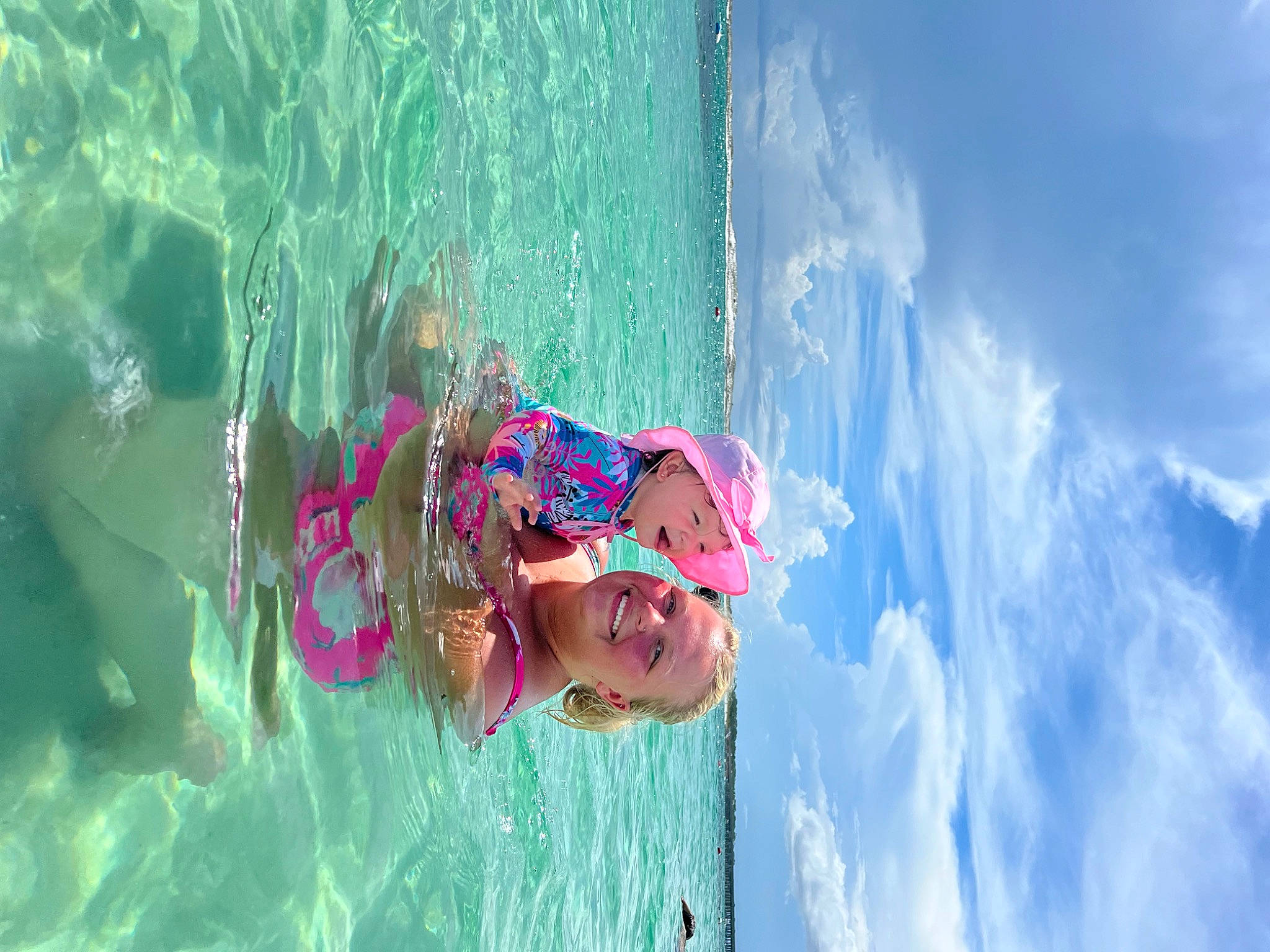 Maci is registered to the contest to win money with this photo: adventure, azure, body_of_water, child, cloud, electric_blue, fun, happy, hat, headwear, joy, leisure, magenta, ocean, person, personal_protective_equipment, recreation, sky, toddler, vacation