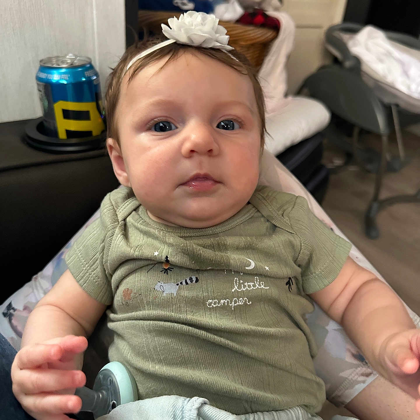 Adleigh joined the competition — help win amazing prizes! baby, blanket, casual, child, clothing, cute, expression, eyes, face, furniture, green_shirt, hand, headband, indoor, infant, living_room, pacifier, person, sitting, young_child