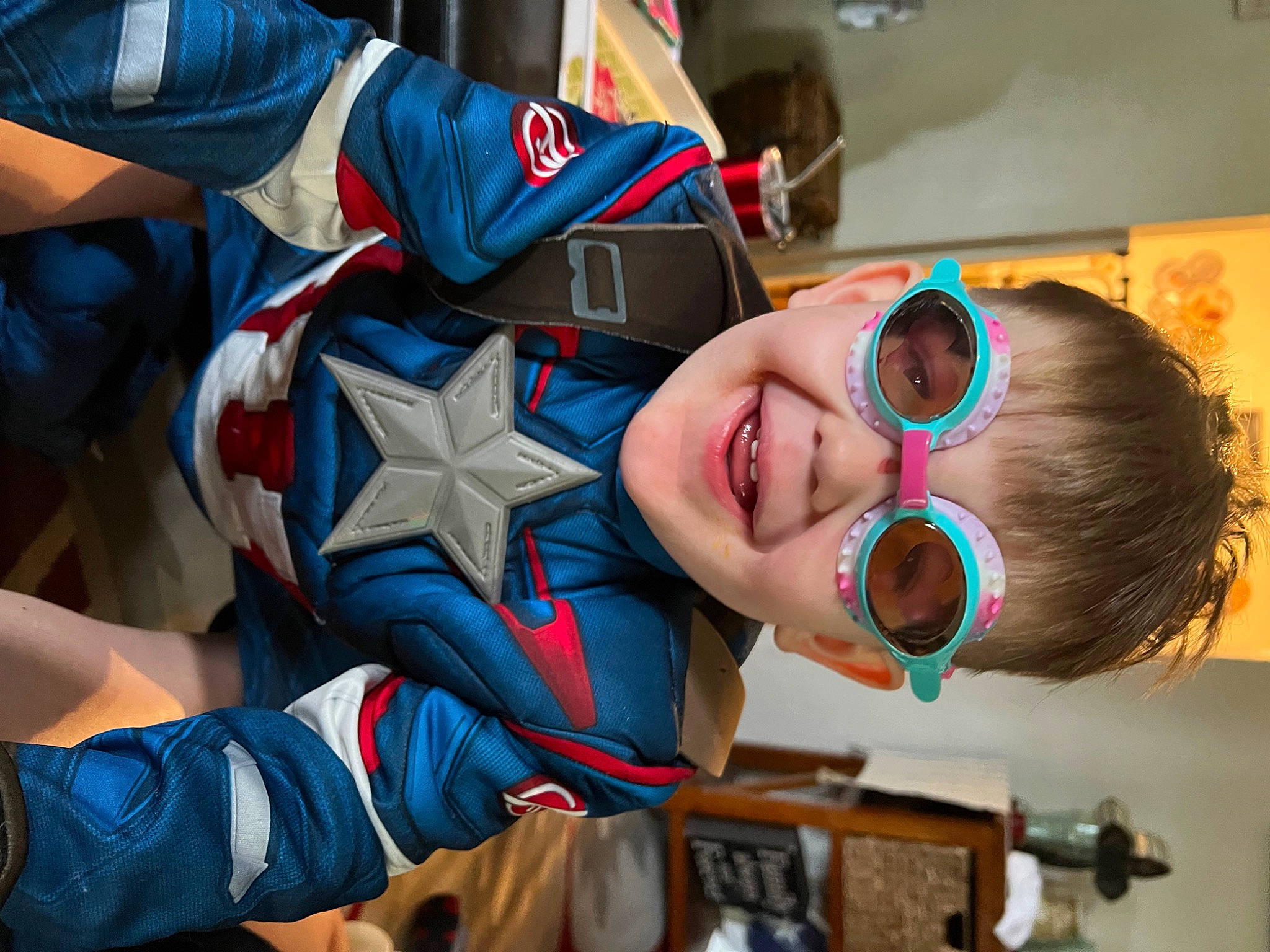 Kamden is registered to the contest to win money with this photo: carmine, child, electric_blue, eye, eyewear, fictional_character, flooring, fun, happy, laugh, leisure, mouth, person, personal_protective_equipment, play, room, smile, t_shirt, toddler, vacation