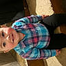 candid, carpet, casual_clothing, child, colorful_clothing, cute, floor_tiles, hair_bow, happy, home, indoor, person, plaid_shirt, portrait, seated, smiling, sneakers, step, toddler, young_child
