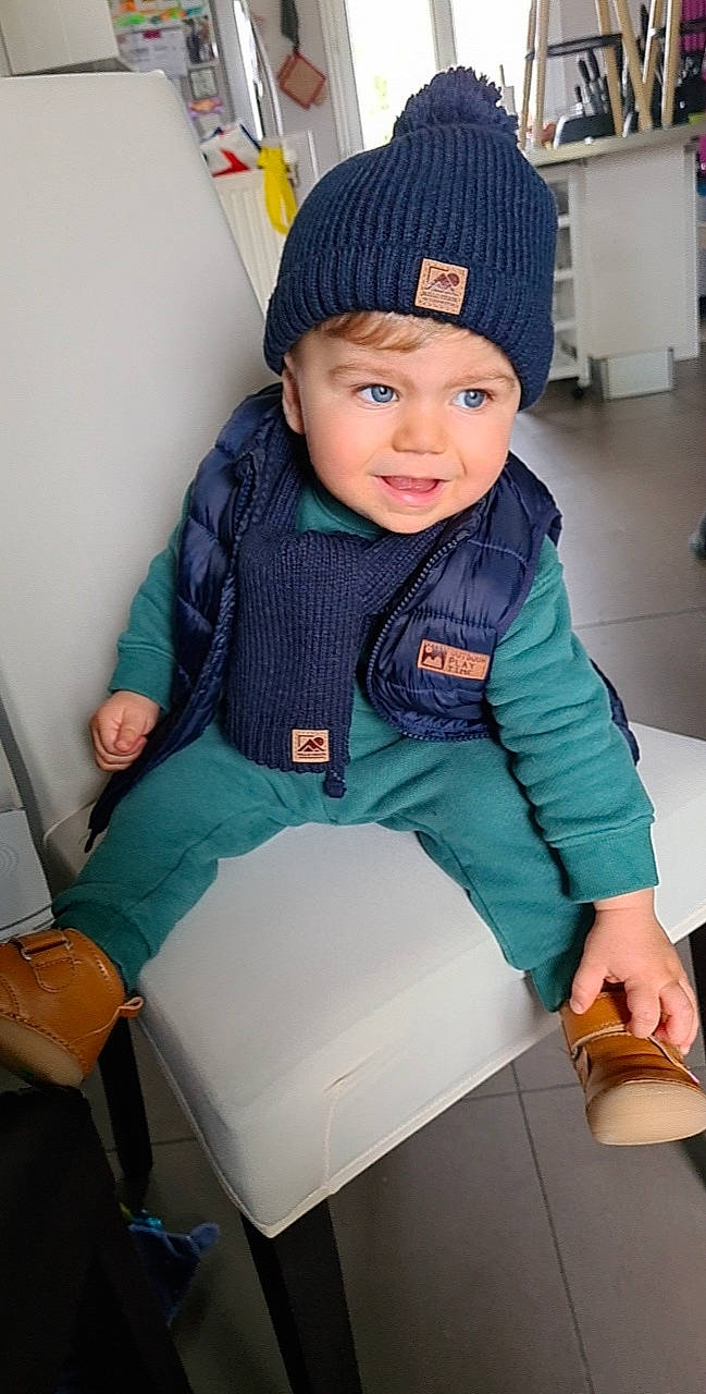 Léo a rejoint le concours — aidez-le/la à gagner de superbes lots ! arm, baby_toddler_clothing, cap, child, comfort, electric_blue, eye, fashion, fashion_accessory, headwear, human_leg, knee, knit_cap, leg, person, photograph, sitting, sleeve, snapshot, thigh