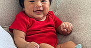 Ethan joined the competition — help win amazing prizes! baby, child, smiling, red_clothing, socks, chair, indoor, furniture, happy, cute, infant, portrait, cozy, candle, home, relaxed, person, skin, head, hair